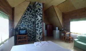 a bedroom with a bed and a tv in a room at Panya Garden Resort in Ban Huai Na (1)