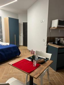a room with a table and a kitchen with a bed at Domus Anna in Bacoli