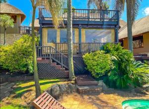 a house with a balcony and a swimming pool at Studio APT with pool and jacuzzi at the golf course in Johannesburg