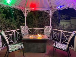 a table and chairs on a patio at night at Studio APT with pool and jacuzzi at the golf course in Johannesburg