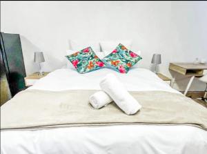 a white bed with two rolled towels on it at Studio APT with pool and jacuzzi at the golf course in Johannesburg +30 photos