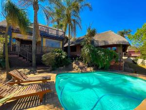 a house with a swimming pool in front of a house at Studio APT with pool and jacuzzi at the golf course in Johannesburg