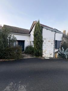 a white house with a tree in front of it at Les lauriers du loft in Pazayac