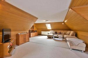 a large living room with a couch and a tv at Gerstels Ferienhof in Hörselberg-Hainich
