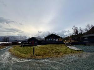 a house with a slide in front of it with mountains at Big cabin in Lyngen Fjords in Jægervatnet +37 photos