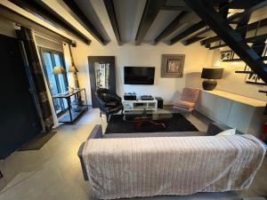 a living room with a couch and a tv at Les lauriers du loft in Pazayac