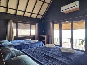 two beds in a room with blue walls and windows at Ko Phangan Beach Cottages in Ban Tai