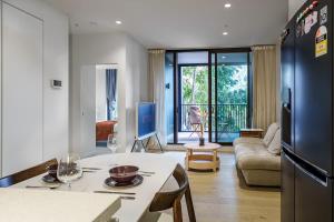 a kitchen and living room with a table and a refrigerator at Premium South Melb 2 Queens Study Pool & Gym in Melbourne