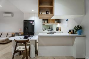 a white kitchen with a sink and a counter at Premium South Melb 2 Queens Study Pool & Gym in Melbourne