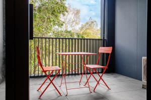 two chairs and a table on a balcony with a window at Premium South Melb 2 Queens Study Pool & Gym in Melbourne