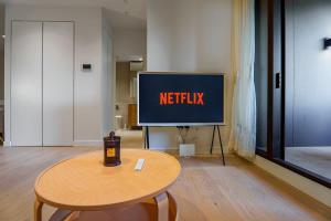 a tv in a room with a table in front of it at Premium South Melb 2 Queens Study Pool & Gym in Melbourne +13 photos