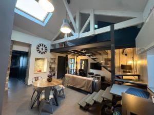 a living room with a loft bed and a table at Les lauriers du loft in Pazayac