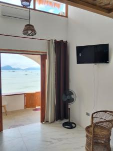 a living room with a view of the ocean at Alfa Beachfront Lofts in El Nido