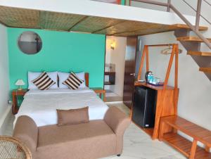 a bedroom with a bed and a couch in a room at Alfa Beachfront Lofts in El Nido