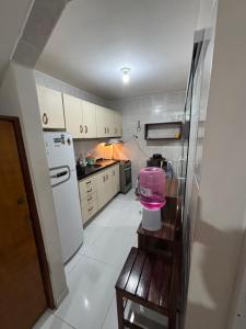 a kitchen with a refrigerator and a table in it at Apartamento na Praia do Francês AL in Praia do Frances