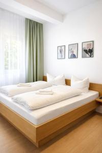 a bedroom with a large bed with white sheets at Gästehaus Kühnle in Bad Wildbad