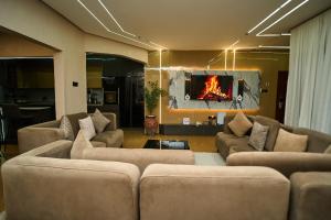 a living room with couches and a fire in the wall at Emiez Apartment and Hotel in Benin City