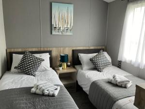 two beds sitting next to each other in a bedroom at Seafront Serenity Lodge in Newbiggin-by-the-Sea