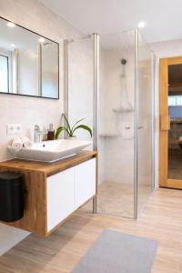 a bathroom with a white sink and a shower at Andi's Auszeit in Dörpen +13 photos
