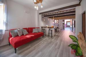 a living room with a red couch and a table at B&B da Baba in Ghizzano