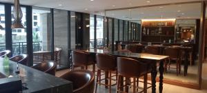 a bar with brown chairs and tables in a restaurant at Knightsbridge Residences with Free Pool, Sauna, Fast WiFi, Gym and Kitchen in Manila