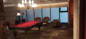 a red pool table in a room with chairs at Knightsbridge Residences with Free Pool, Sauna, Fast WiFi, Gym and Kitchen in Manila