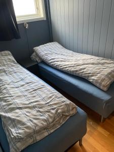 zwei Betten, die in einem Zimmer nebeneinander stehen in der Unterkunft Birthebu in Kjerrvika