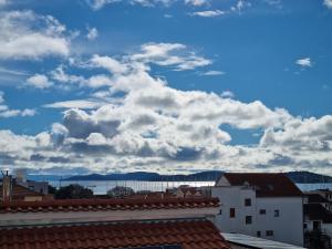 a view of a cloudy sky with buildings and roofs at Lion Apartments in Vodice