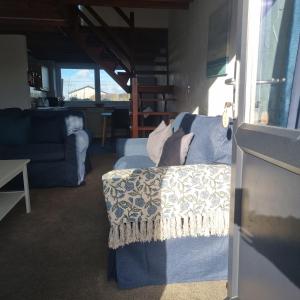 a living room with a blue couch and a table at Penrhyn Cottage Tyn Don in Llanengan