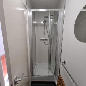 a shower with a glass door in a bathroom at Penrhyn Cottage Tyn Don in Llanengan