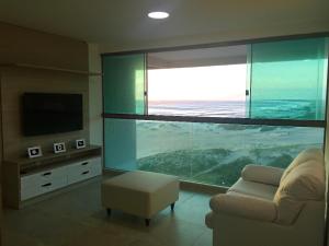 a living room with a couch and a large aquarium at Orla Praia Grande in Arraial do Cabo