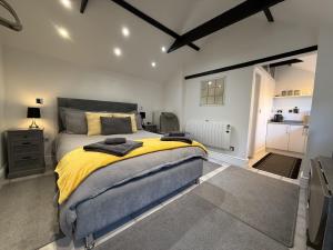 a bedroom with a large bed with a yellow blanket at Crossways Beech Tree in Grimsby