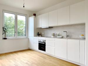 a white kitchen with white cabinets and a window at Berlin in Niederdorla