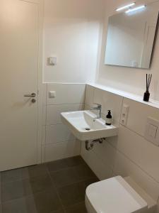 a white bathroom with a sink and a toilet at Berlin in Niederdorla