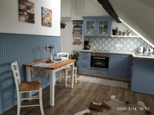 a kitchen with blue cabinets and a table and chairs at Ferienwohnung Luna in Trier +15 photos