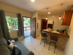 a kitchen and living room with a couch and a counter at Pousada Peninsula Santa Rita in Guarapari