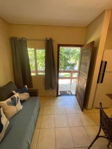 a living room with a couch and a sliding glass door at Pousada Peninsula Santa Rita in Guarapari +51 photos