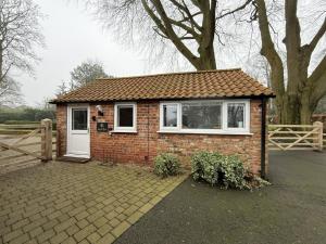 a small brick house with a white door at Crossways Beech Tree in Grimsby +14 photos
