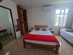 a bedroom with a large bed with a red blanket at Belle terre sur mer in La Ferme