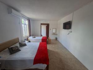 a hotel room with two beds and a television at Belle terre sur mer in La Ferme