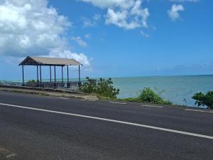 a road with a gazebo next to the ocean at Belle terre sur mer in La Ferme