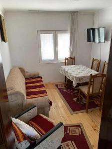 a living room with a couch and a table at Apartmani Petrović - 3 cozy family apartments in Kaludjerske Bare
