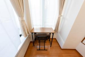 a small table in a small room with a window at NTK House Yokohama in Yokohama