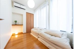 a white couch in a room with a large window at NTK House Yokohama in Yokohama