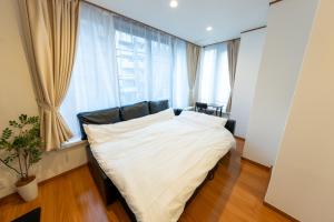 a bedroom with a large bed in front of a window at NTK House Yokohama in Yokohama