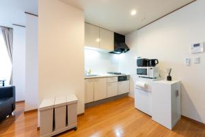 an apartment kitchen with white appliances and a couch at NTK House Yokohama in Yokohama +65 photos