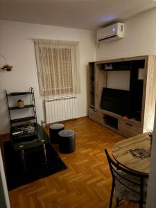 a living room with a television and a table at Barbello in Stara Pazova