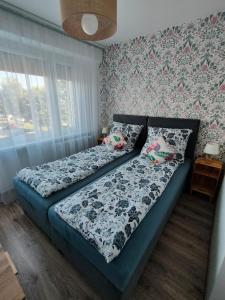 a bedroom with a bed with a floral wallpaper at Apartament Prudniczanka in Prudnik