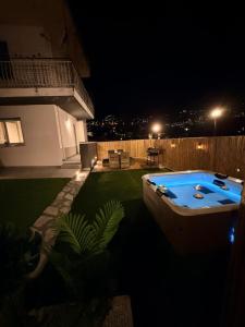 a backyard with a hot tub in the yard at night at Satori House in Sanremo
