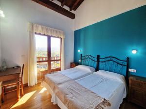 a bedroom with a large bed with a blue wall at Hotel Verdemar by Grupo A Cobijo in Lamadrid +37 photos